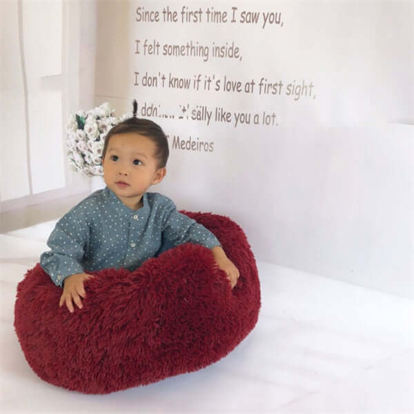 Cozy cat mattress design shown with a child sitting comfortably in a plush, red nest pad pet bed.
