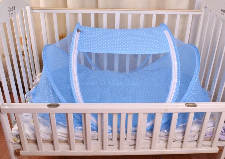 Portable baby mosquito net bed in a crib with breathable mesh and blue design for baby safety.