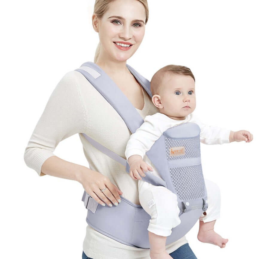 Mother using ergonomic baby carrier with waist support, carrying infant comfortably in multiple positions.