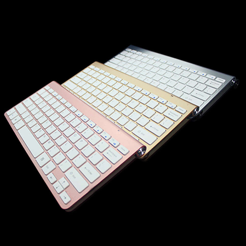 Wireless Bluetooth keyboard mouse combo with pink, gold, and silver colors on a black background.
