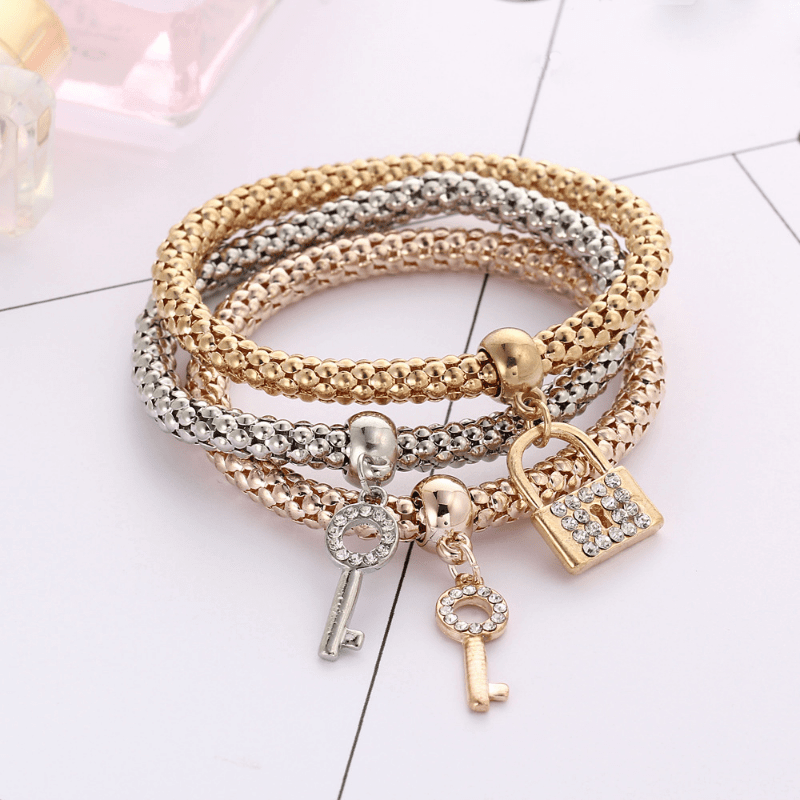 Lock and key bracelet set featuring sparkling rhinestone accents in gold and silver tones, perfect for couples.