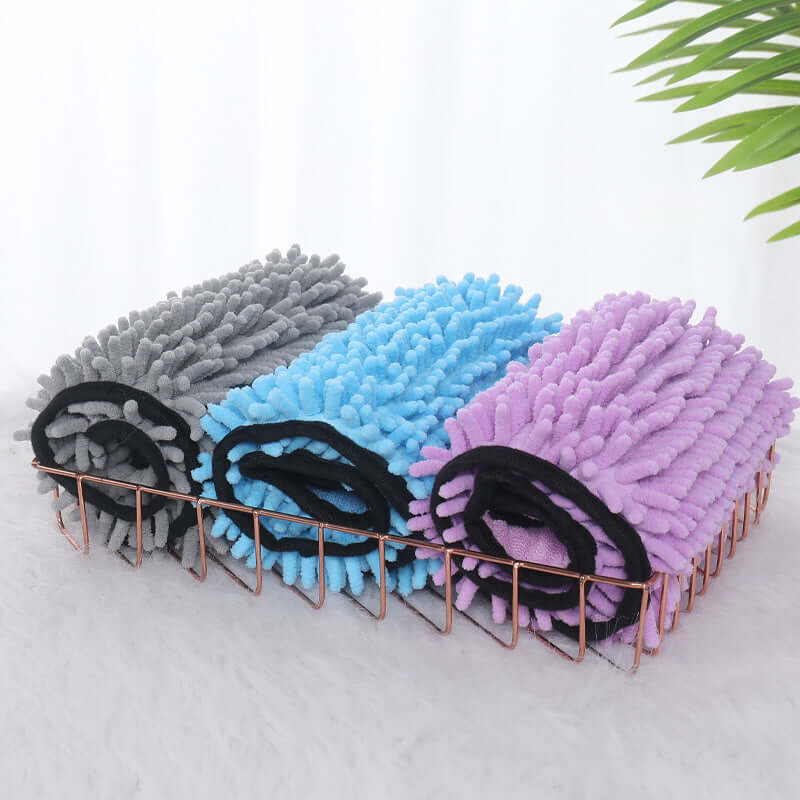 Collection of super absorbent dog bathrobe towels in gray, blue, and purple stacked in a stylish wire basket.