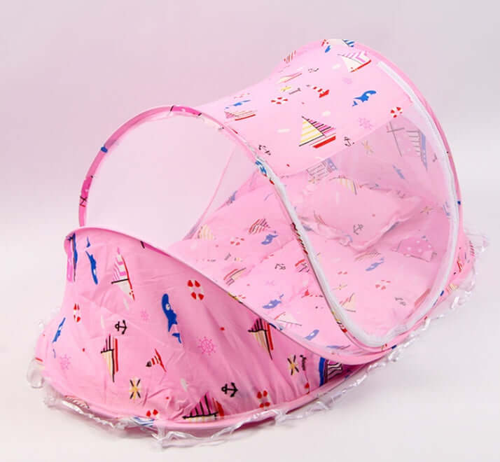 Portable baby mosquito net bed in pink with breathable mesh and comfortable mattress and pillow.