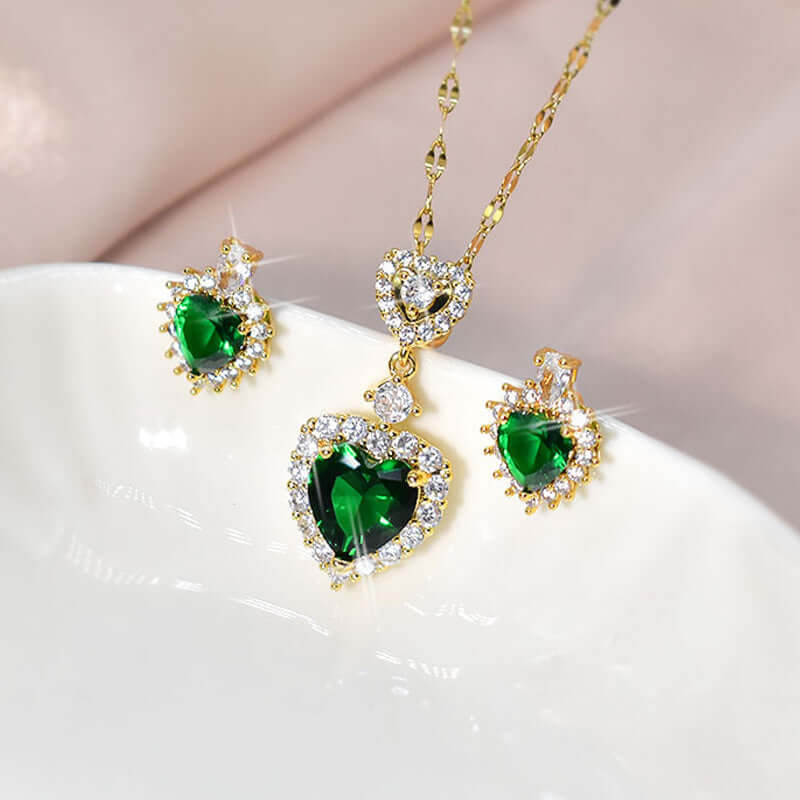 layered women's necklace set featuring green heart-shaped gems and matching earrings in gold setting