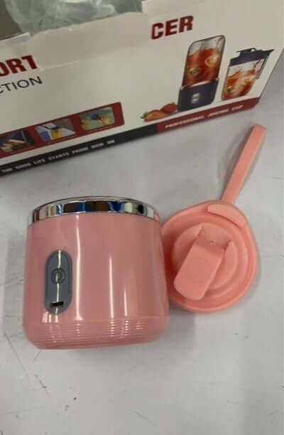 portable USB juicer machine in pink with lid and button on display next to the packaging.