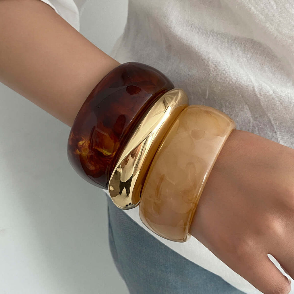 Handcrafted resin-dyed bracelet worn stacked, showcasing vibrant color patterns and unique designs.