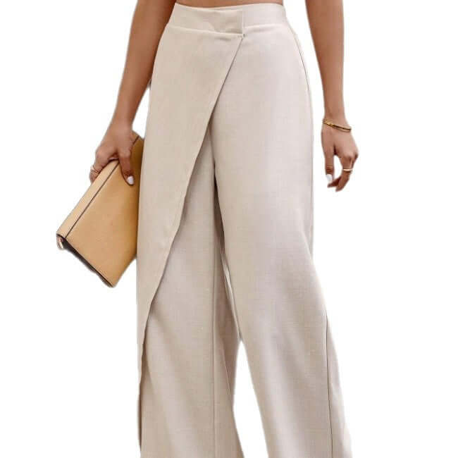 High-waist patchwork suit pants in beige worn with a clutch, showcasing a relaxed fit and elegant design.