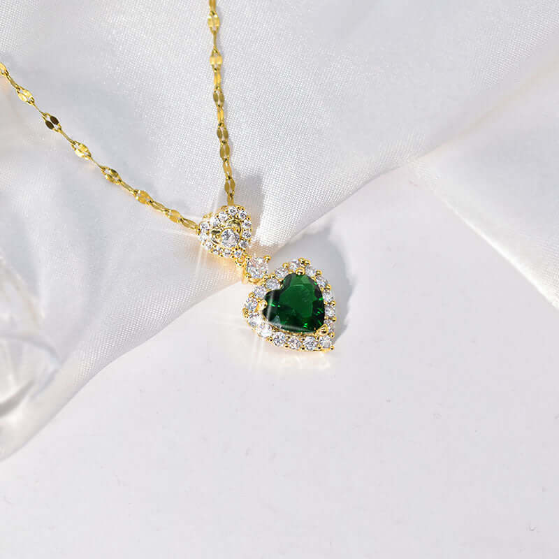 Layered women's necklace set featuring a beautiful green heart pendant and sparkling accents on a delicate gold chain.