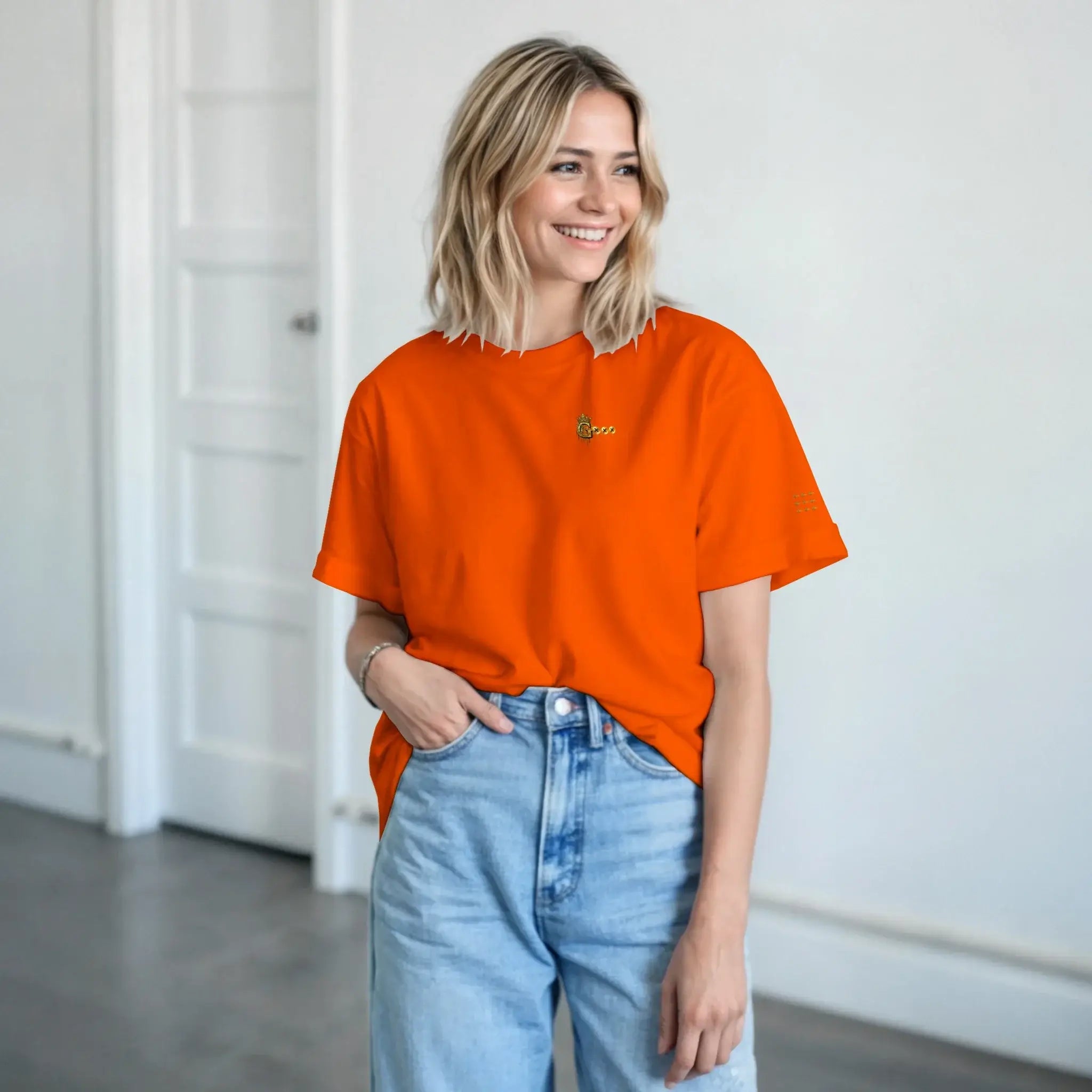 Smiling model wearing a heavyweight unisex t-shirt in vibrant orange, paired with light blue jeans.