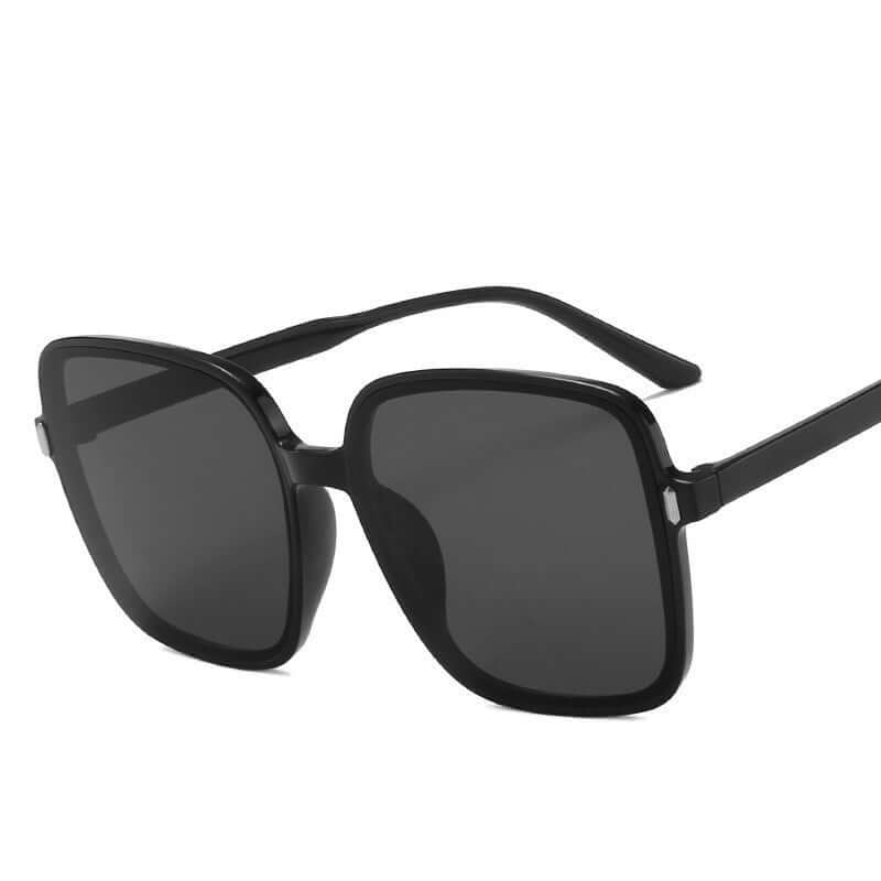 Fashionable big square sunglasses with black frame and dark lenses perfect for sunny days.