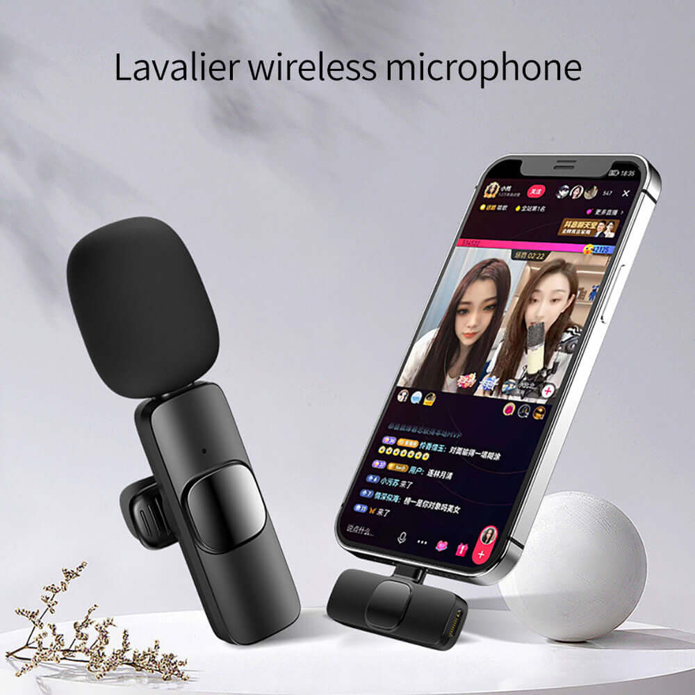 Wireless clip-on microphone with noise reduction alongside smartphone in live broadcast setup.