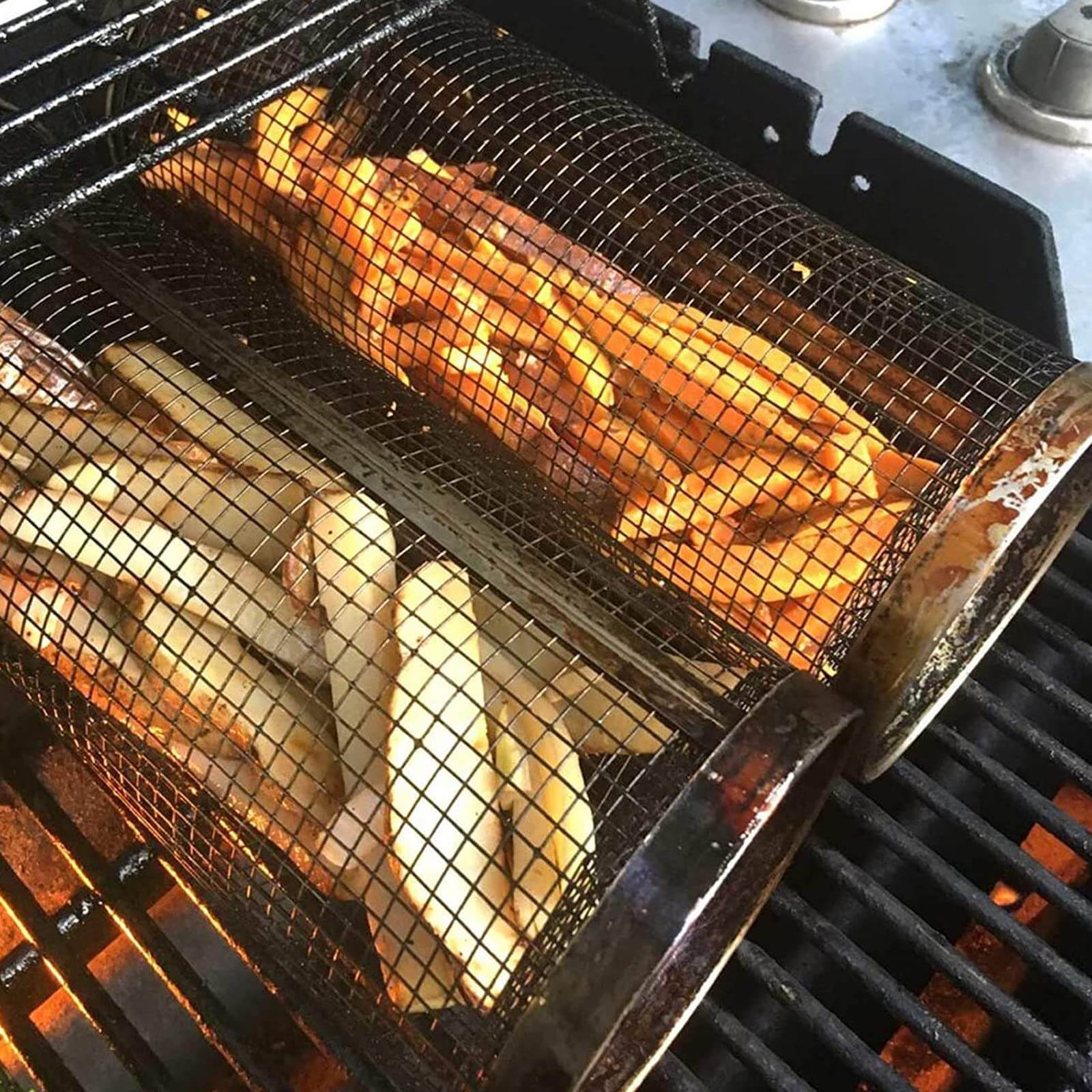 Stainless steel grill basket on BBQ grill with sweet potato and regular fries cooking evenly.