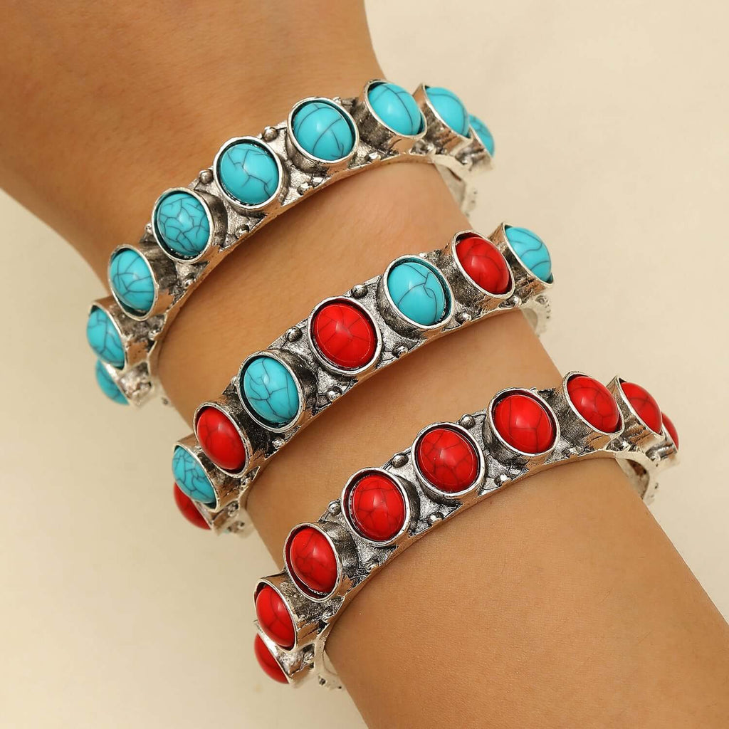 Three ring-shaped electroplated alloy bracelets in red and blue on wrist, showcasing bold statement jewelry for women.