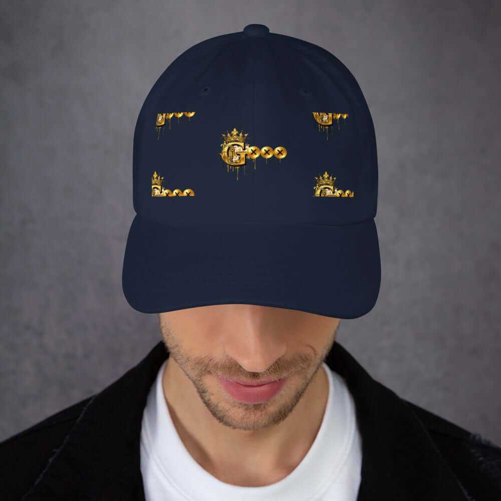 Model wearing a navy blue low profile dad hat with gold crown and dripping graphic designs.