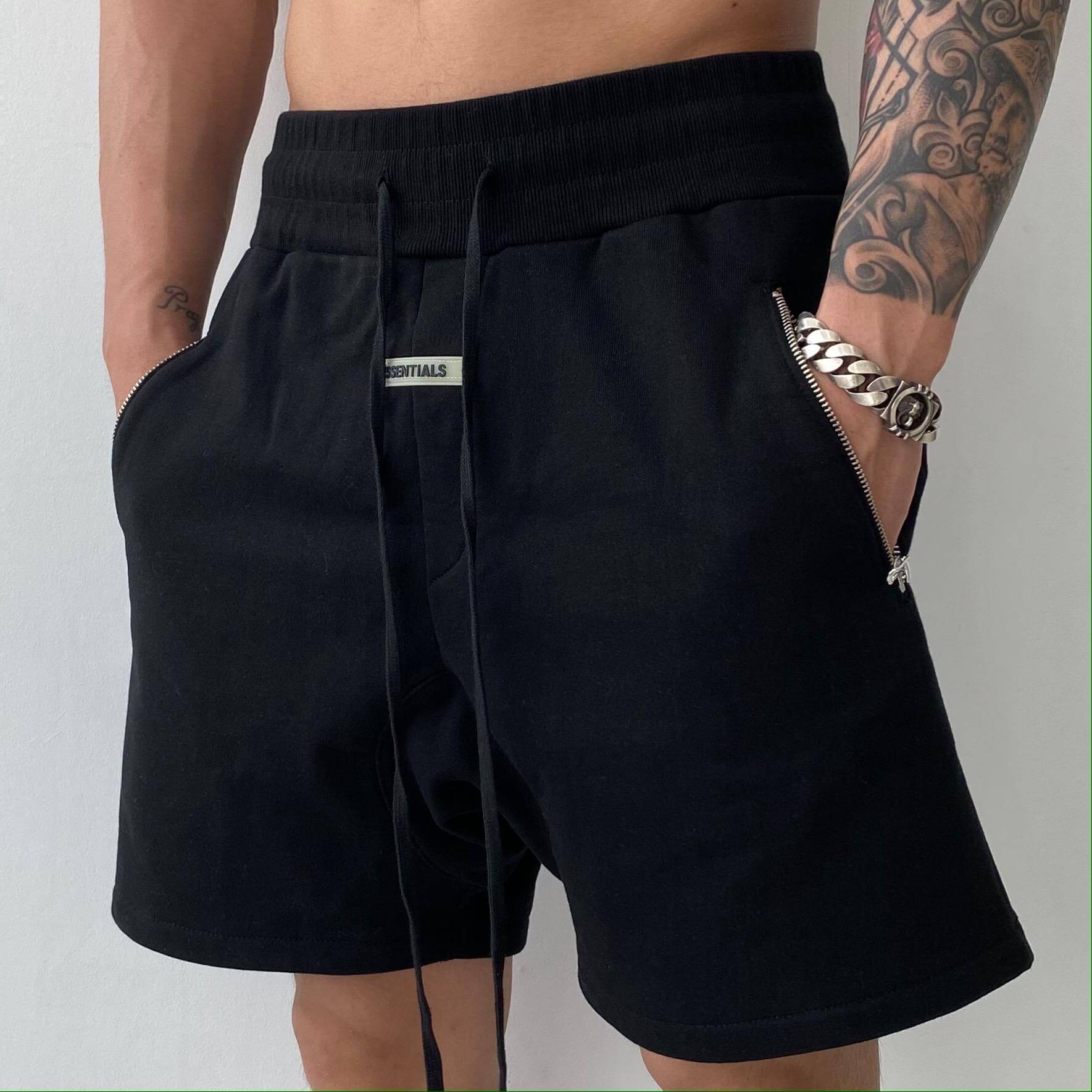 Stylish model wearing lightweight men's fitness shorts with pockets, perfect for gym and training.