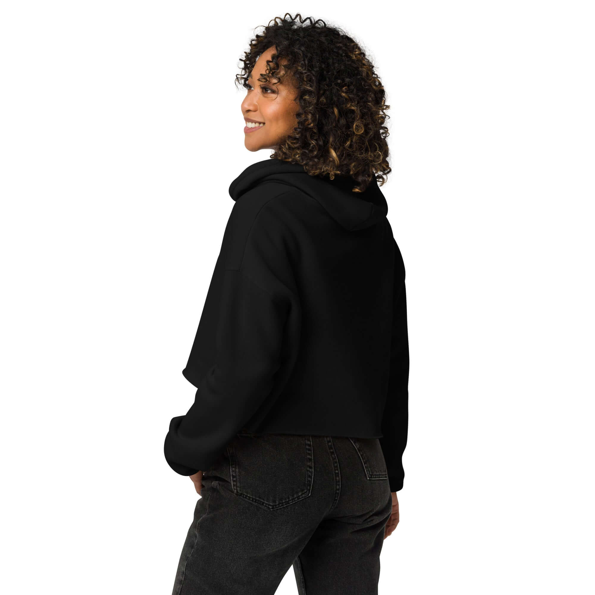 Trendy crop hoodie showcased on a model with curly hair, featuring a cropped design and raw hem from the back.