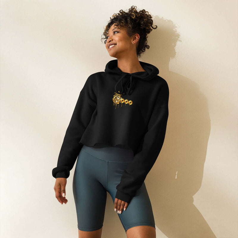 Smiling model wearing a trendy crop hoodie with a raw hem, paired with cycling shorts, showcasing stylish casual wear.