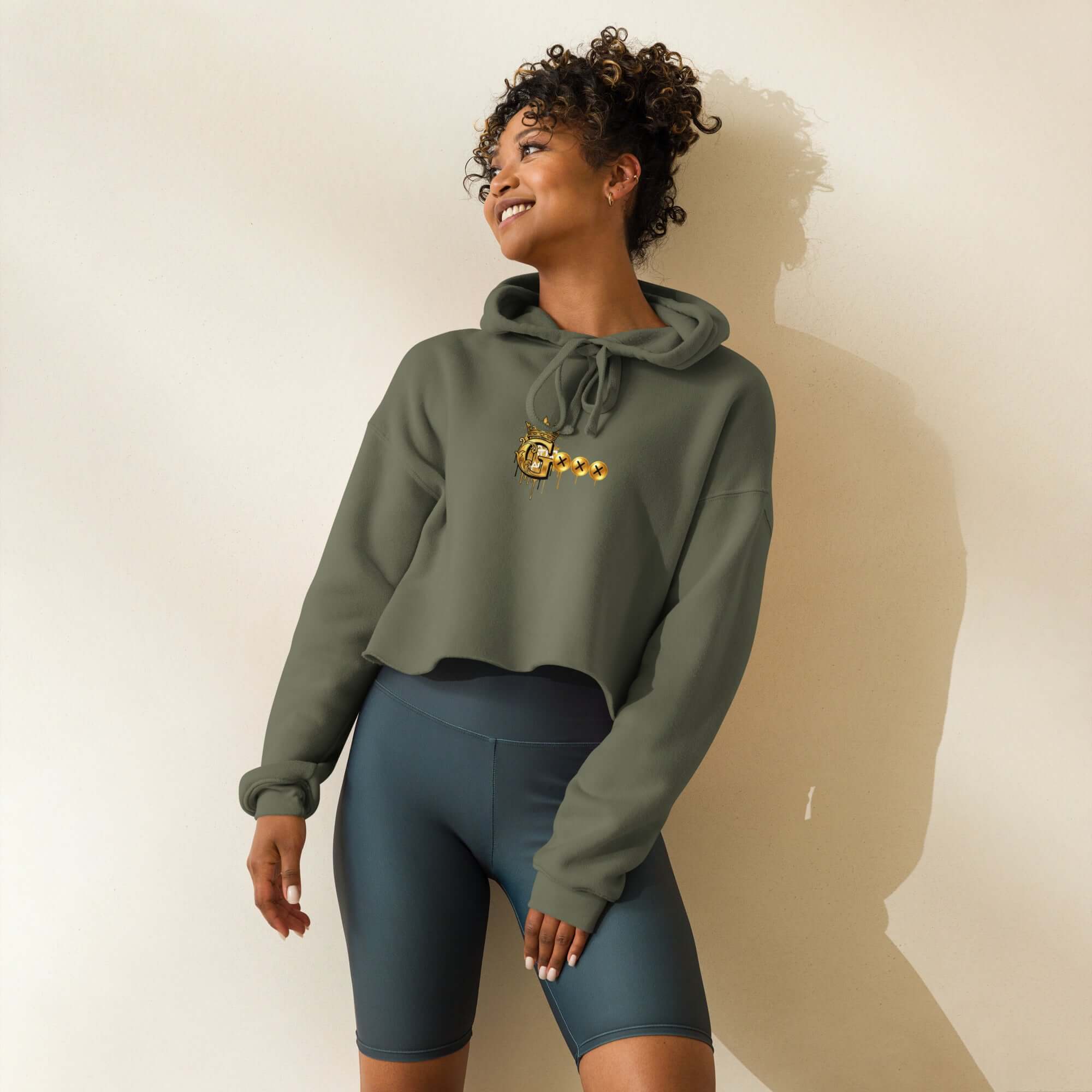 Trendy crop hoodie worn by a model, featuring a cropped design and matching drawstrings in olive green.